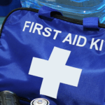 A close-up of a first aid kit, important documents, and water.