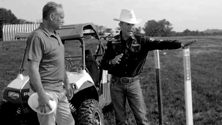 Black & White photo of JJ in the Field next to a marker post